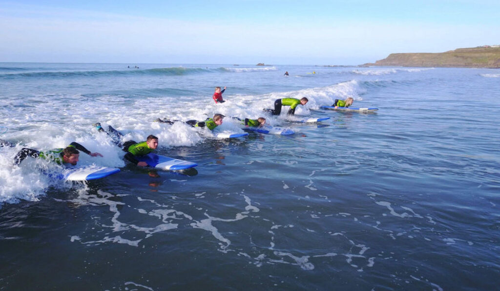 group surf lesson everyone catching wave together 1024x768 1 1118x752