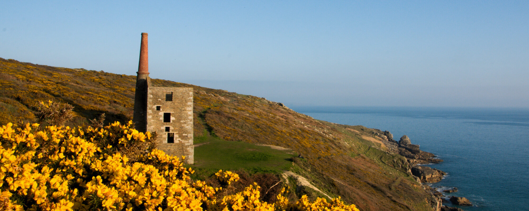 The Wheal Prosper engine house perched on cliffs at Rinsey Head near Porthleven, Cornwall