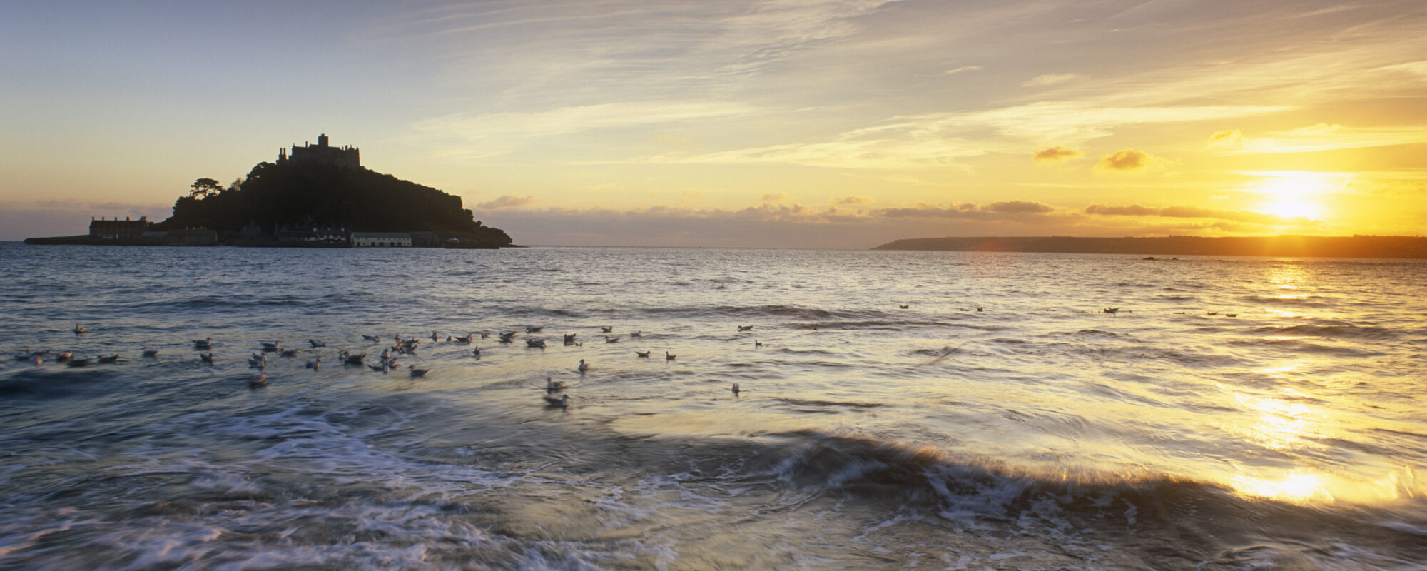 St Michael's Mount, Cornwall, silhouetted against the sky at sunset.