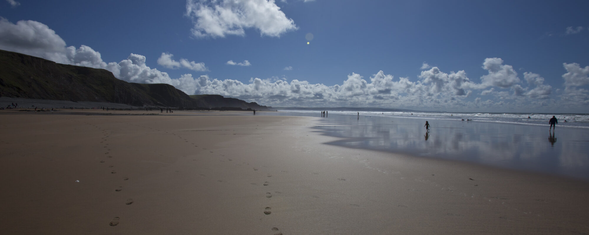 Walkers on the beach at Sandymouth, Cornwall.