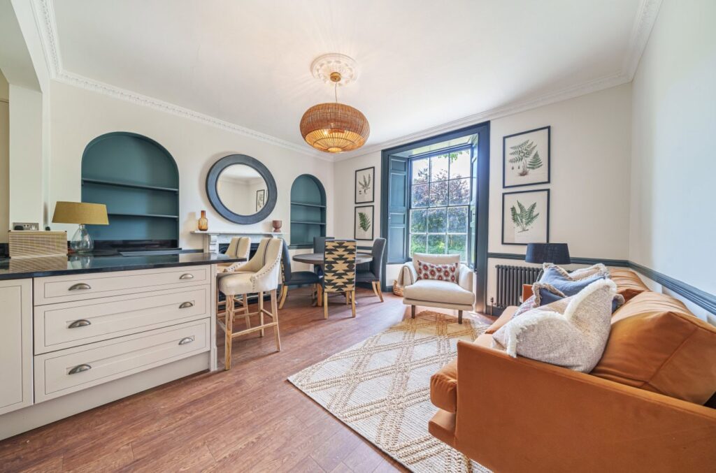 Bright living room with sofa, armchair, and decorative wall art.