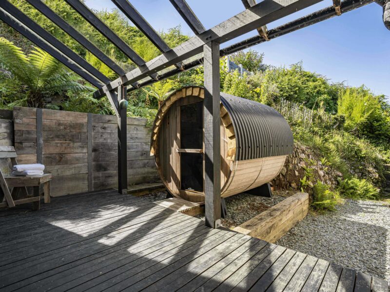 Relaxing outdoor wooden barrel sauna with garden views at Cornish Secrets.
