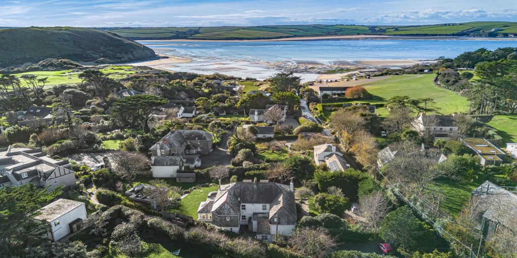 Coastal village in Cornwall with lush gardens, scenic landscape, and ocean views, ideal for holiday retreats.
