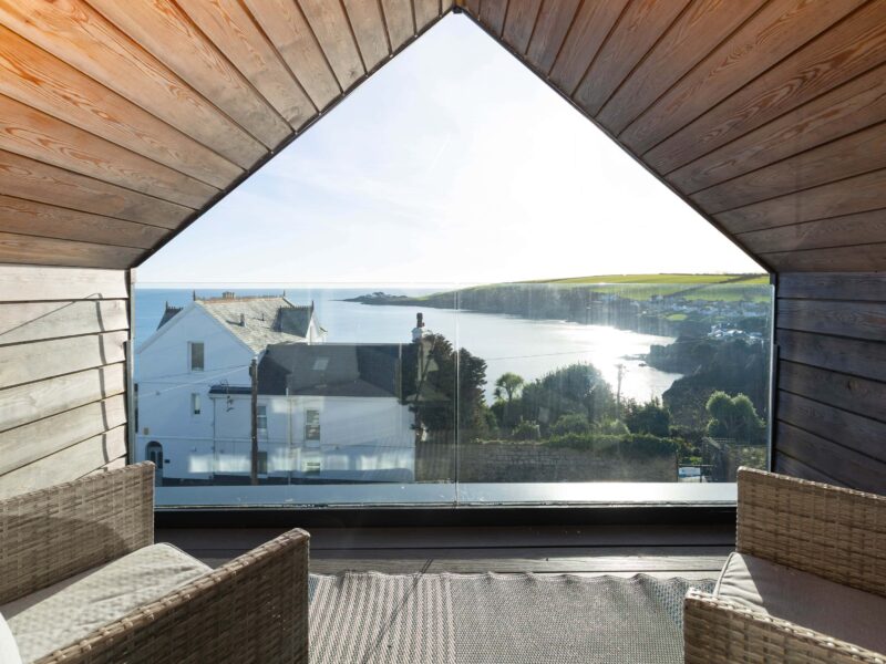 Bright, modern balcony offering stunning ocean and coastline views from Cornish Secrets. Perfect for relaxation.