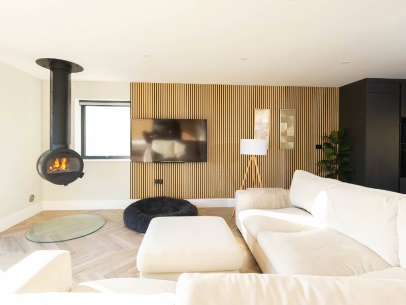 Stylish living room featuring a contemporary fireplace, wooden accent wall, and comfortable seating in Cornwall.