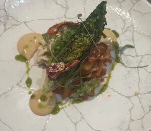 Delicious gourmet dish featuring fresh greens, seafood, and vibrant sauces, showcasing Cornwall's cu.