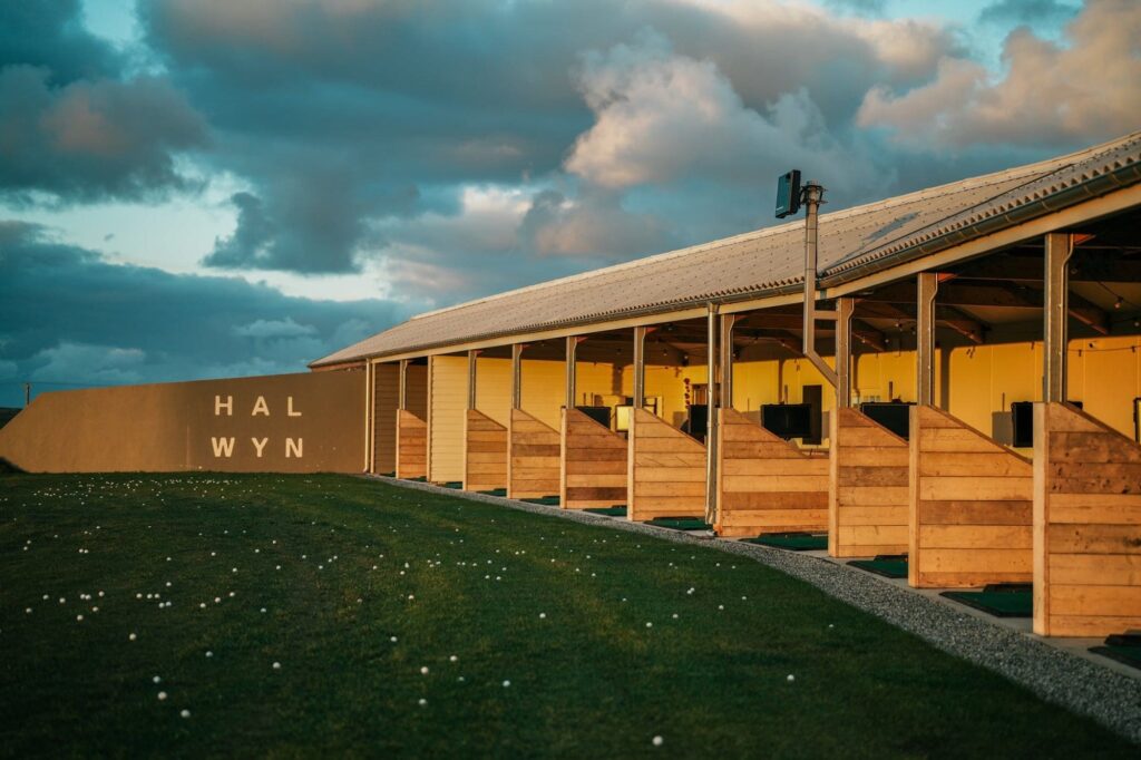 Modern sports facility at Halwyn with wooden seating and scenic sky backdrop.
