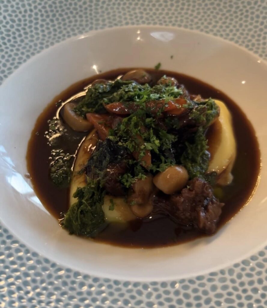 Gourmet dish with vegetables, mushrooms, and rich sauce at Cornish Secrets.