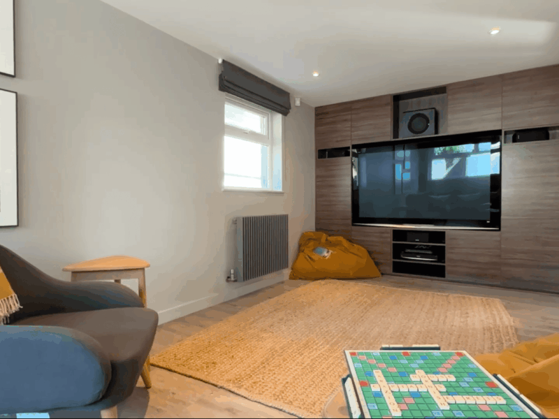 Coastal living room with modern decor, large TV, and natural light in Cornwall. Perfect for relaxing.