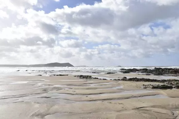 Distant view of Stepper Point across winter seas from the beach at Polzeath, North Cornwall. National Trust Images, John Gerrish.