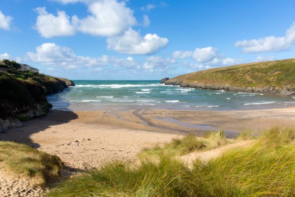 Cornish cove Porthcothan Bay north coast Cornwall England UK between Newquay and Padstow on a sunny blue sky day with hut. © Charlesy, Shutterstock